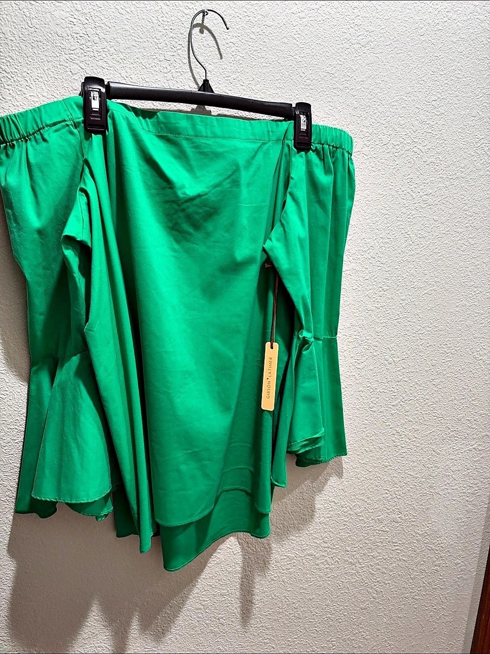 Vibrant green off shoulder blouse with long sleeves.
